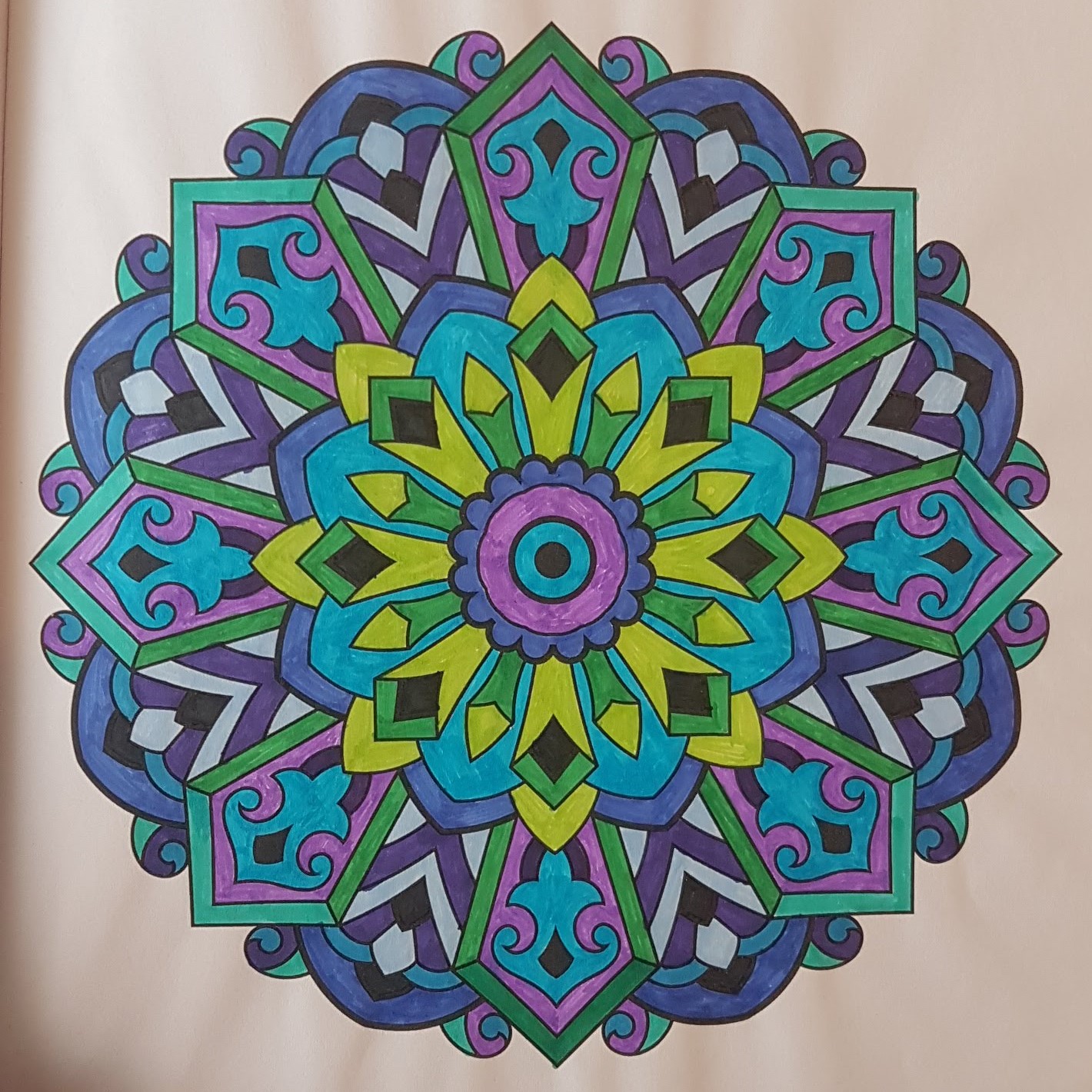 A mandala with purple circles in the center, with green spiky shoots around that, and purple and blue pendant shapes towards the outside